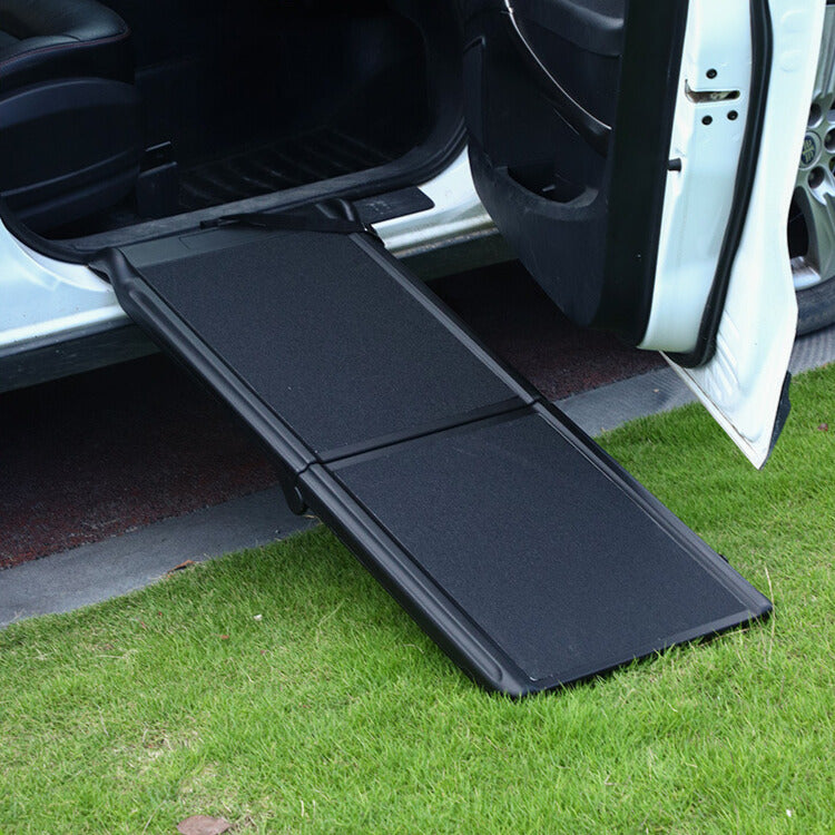 Foldable dog ramp for car positioned at side door, portable pet ramp on grass