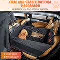 Small poodle sitting in black dog car seat with mesh sides
